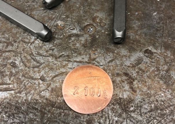 old pennies are used for the frame number, pressed and re-punched.