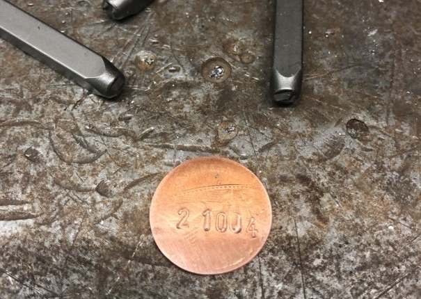 old pennies are used for the frame number, pressed and re-punched.